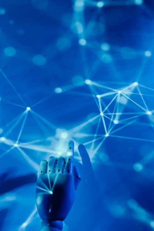 A robotic hand reaching toward a lattice of connected nodes