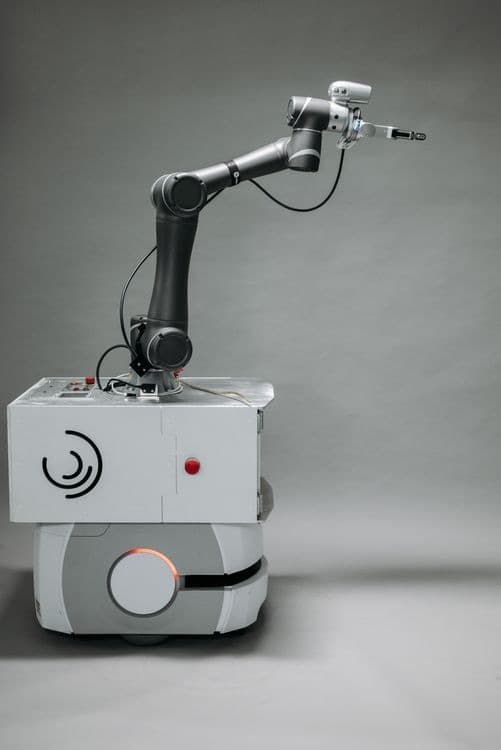 A mobile robot with an articulated arm against a grey backdrop